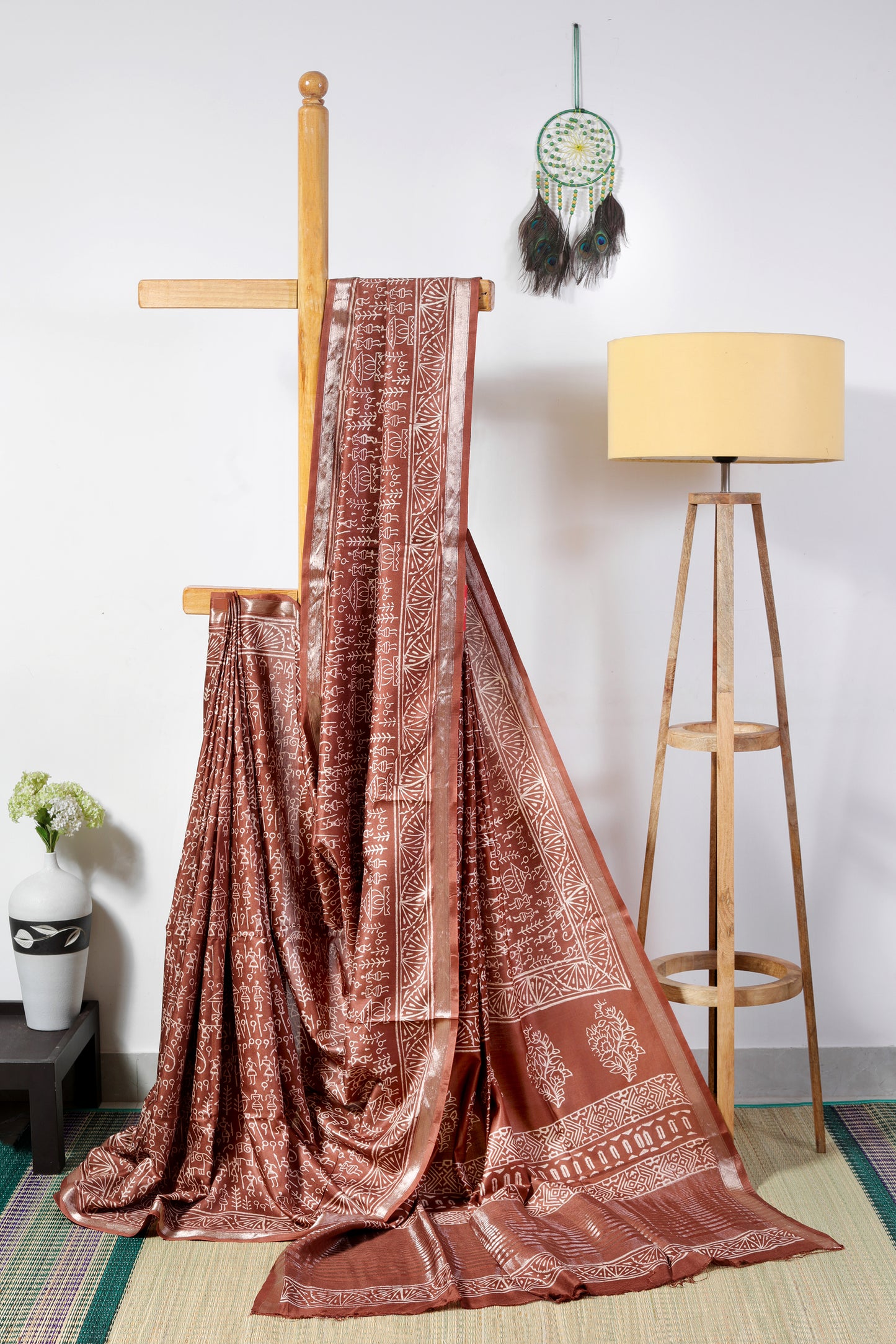 art silk crepe- brown body with off white tribal prints finished with a patterned border and zari