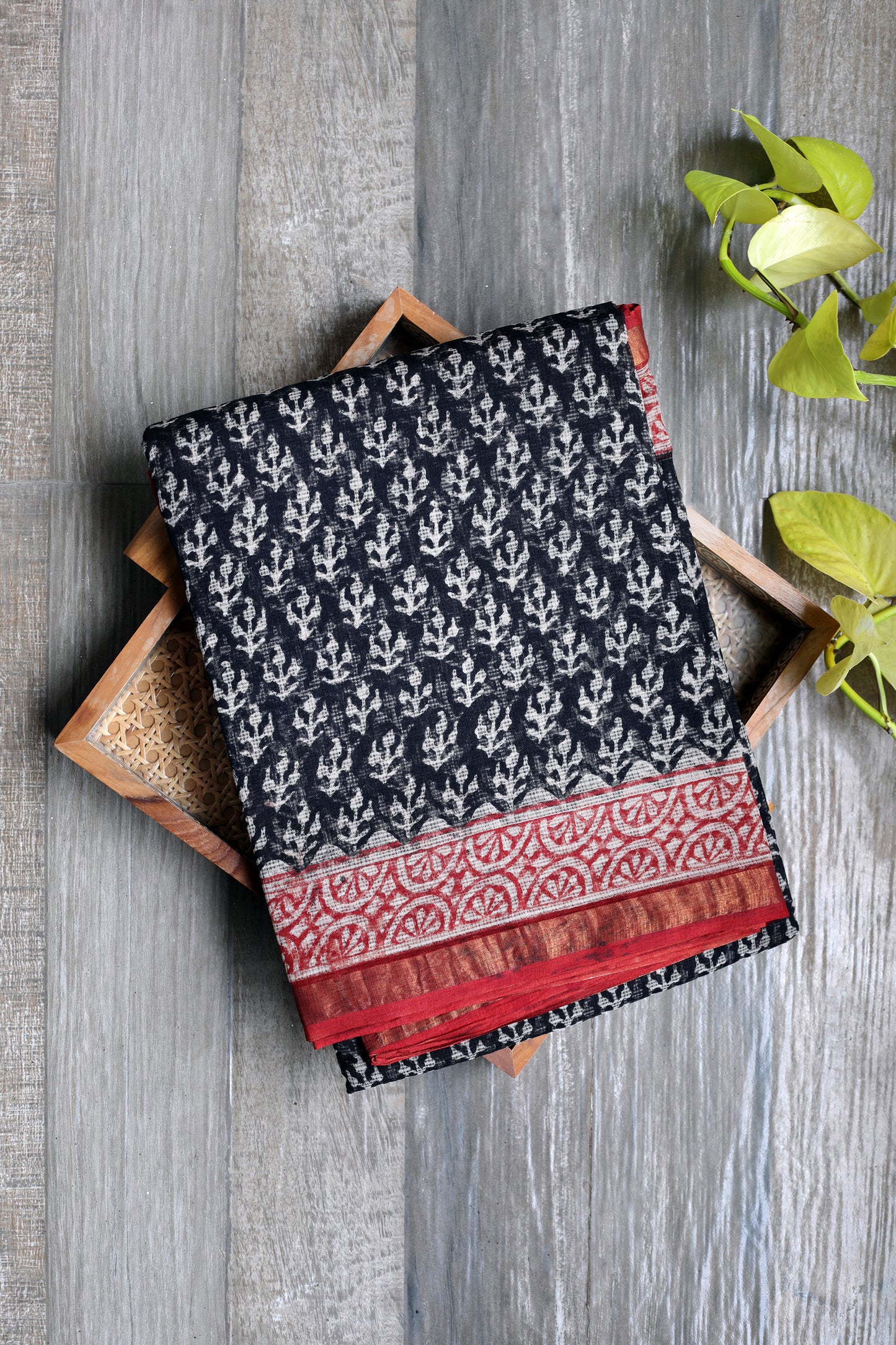 beautiful Kota Doria saree in timeless black, hand block-printed in classic white Bagru motifs. Finished with a striking brick red border, this piece weaves together heritage and style — light, airy, and perfect for effortless grace