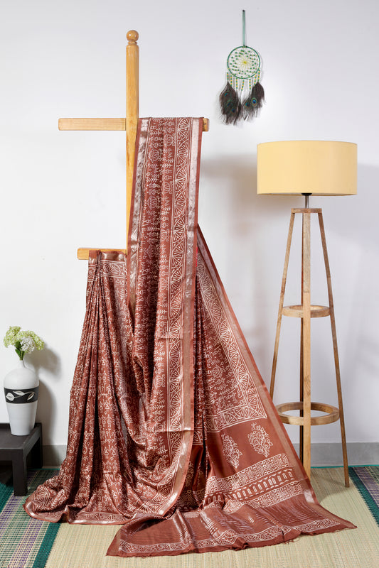 art silk crepe-  brown body with off white tribal prints finished with a patterned border and zari