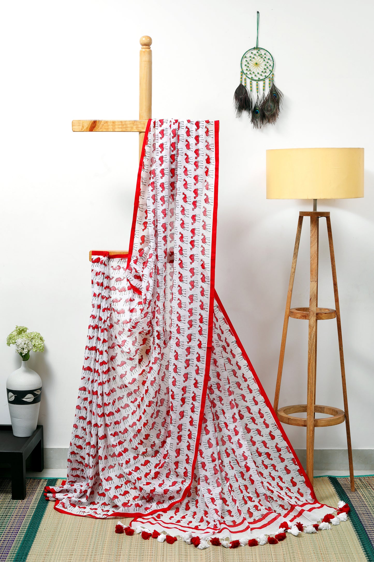 this feather-light milky white mul cotton and skin-loving, &nbsp;saree with quirky camel prints in red blends storytelling with style