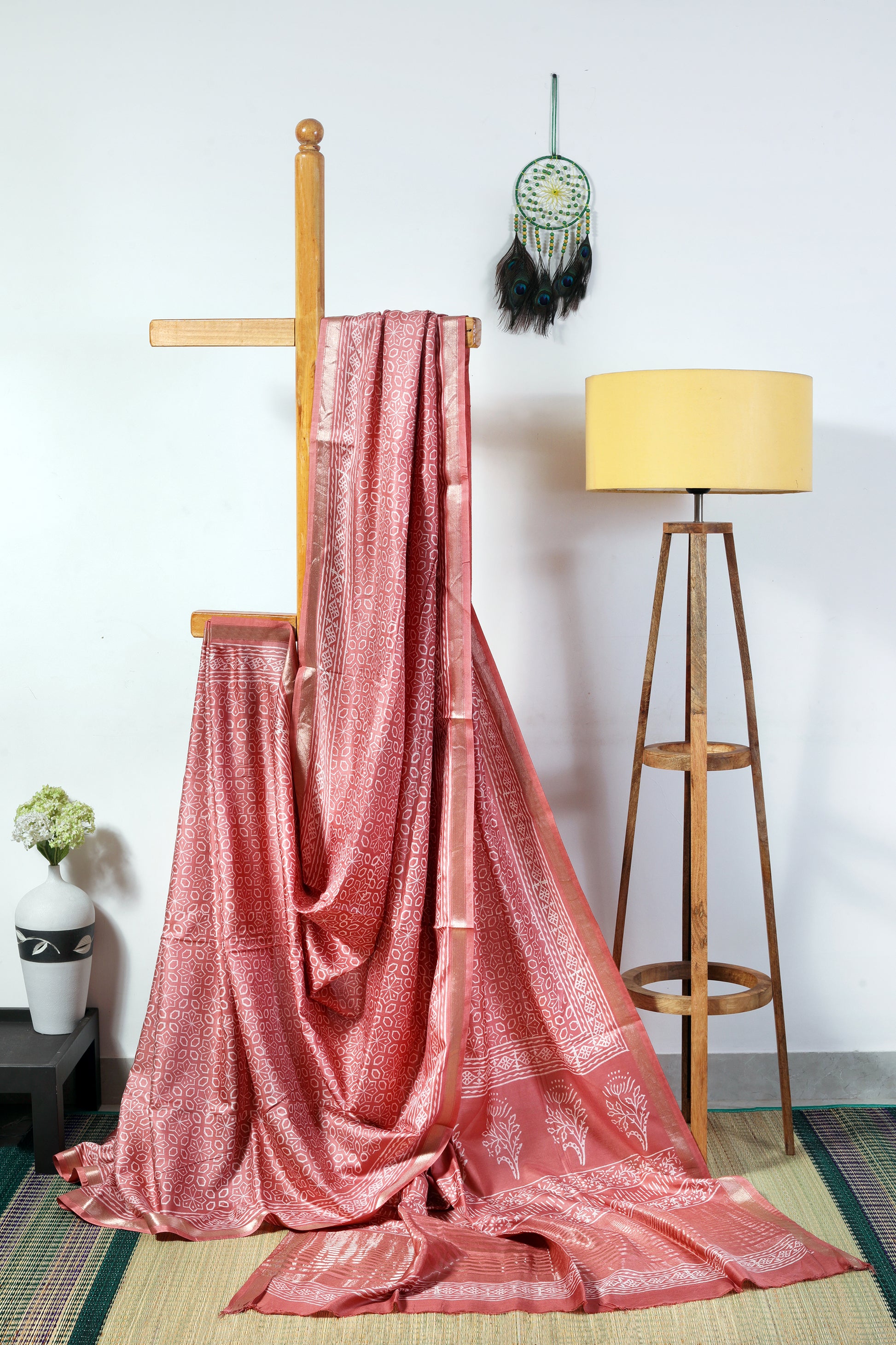 art silk crepe- light brown body with off white rangoli prints finished with a patterned border and zari